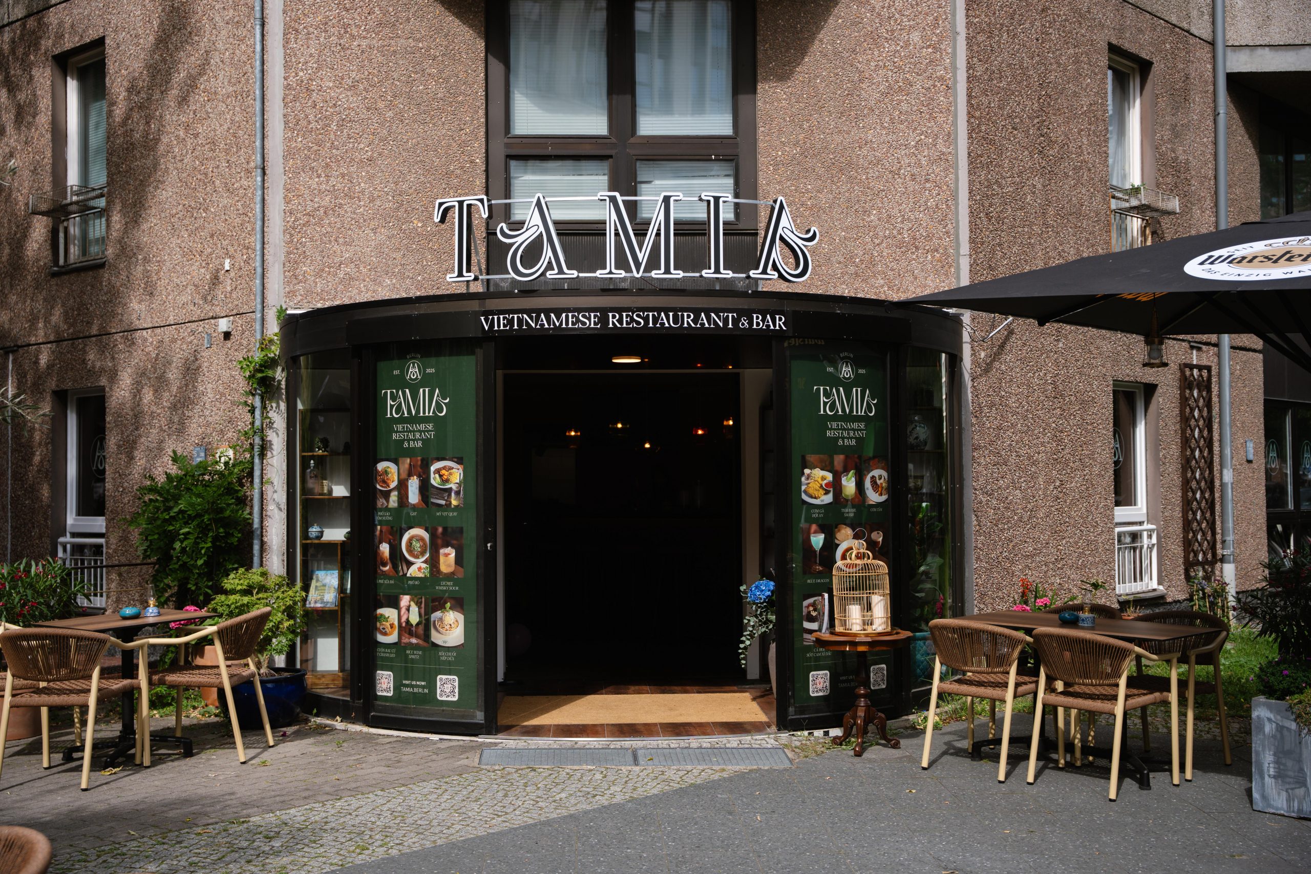 Vietnamese restaurant Tamias exterior with green menus on glass doors and outdoor seating under a large sign 'TAMIS'
